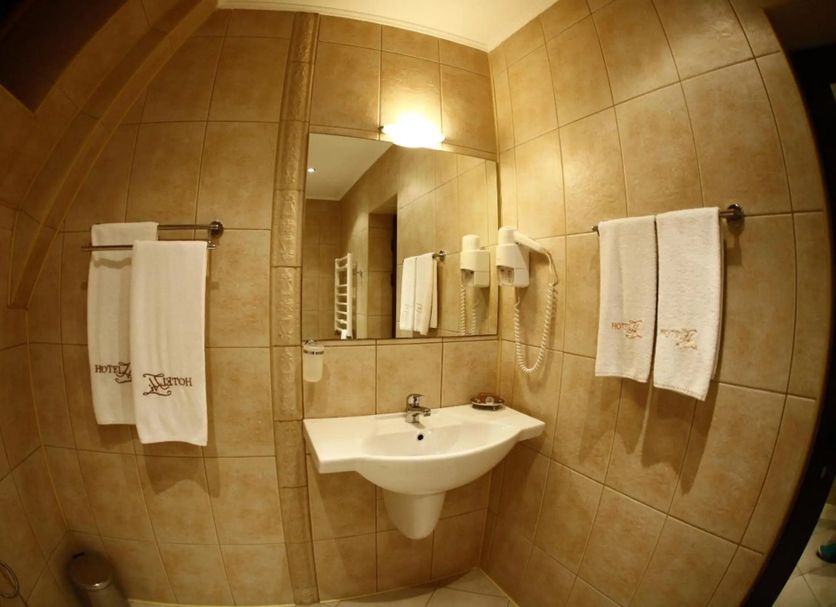 Hi Boutique Hotel Varna bathroom with sink, mirror, wall-mounted hair dryer and towels