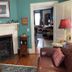 Terrell House B&B in Burnsville living room with fireplace, leather sofa, wicker chair and teal walls