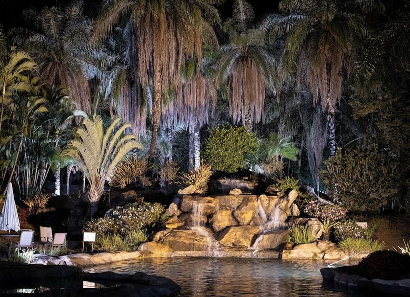 Ville Real Hotel in Ouro Preto with a nighttime garden waterfall and poolside seating