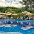 Hotel Villa Mercedes Palenque pool with lounge chairs, umbrellas and lush tropical greenery in Palenque