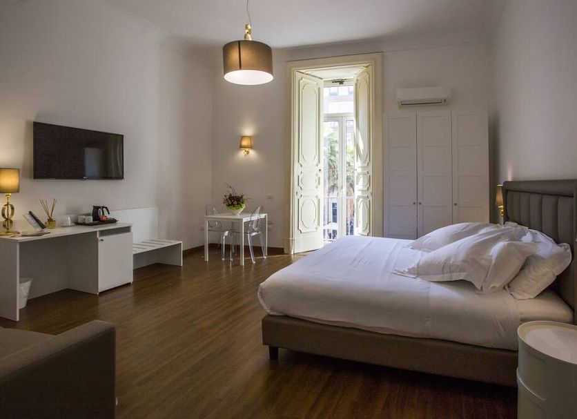 Napoli Class room in Naples with double bed, wall-mounted TV, desk, and balcony doors to the outside