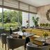 Four Seasons Hotel Bengaluru at Embassy One lounge with yellow sofa, tables, greenery and large windows