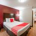 OYO Hotel Mcallen Airport South room in McAllen with bed, red accent wall and wood flooring