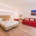 Dimore delle Zagare Ortigia in Siracusa: bright guest room with bed, red sofa, mirror and wall art