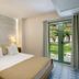 Ulusoy Kemer Holiday Club - Kids Concept room in Göynük with a bed, lamps and balcony doors to greenery.
