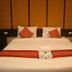 Phu Chom Mork Resort Sangkhla Buri bedroom with king bed, red accents and rolled towels
