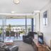Pumicestone Blue in Caloundra, living room with balcony, ocean and town view through sliding glass doors