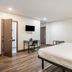 The Greens Hotel on Stockton in Sacramento guest room with bed, desk, wall-mounted TV and chair