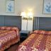 Scottish Inns Mcminnville guest room with two beds and matching patterned bedspreads in McMinnville