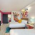 Hotel Zazz Albuquerque guest room with two beds, wall-mounted TV, and colorful giraffe mural