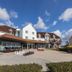 Thermenhotel Kurz in Lutzmannsburg, exterior with patio seating and bicycles under a blue sky