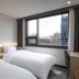 Jamsil Stay Hotel Seoul guest room with twin beds and city view through large window