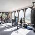 New Hall Hotel & Spa gym in Sutton Coldfield with treadmills, weights, exercise bikes and arched windows.