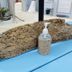 La Isla Resort, Caye Caulker: driftwood soap dispenser on a blue table with sandy beach decor
