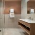 Sky Hotel Apartments Stockholm bathroom with walk-in shower, vanity sink, and towel rack