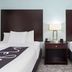 La Quinta Inn & Suites by Wyndham Bonita Springs Naples N. guest room with two double beds and bedside lamp