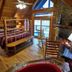 A Cabin In The Woods cabin bedroom in Pigeon Forge with stone fireplace, lofted wood ceiling and balcony view