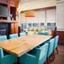 Hilton Garden Inn Virginia Beach Town Center meeting room with wooden table, turquoise chairs, and fireplace