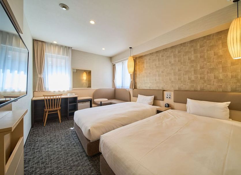 Via inn Kyoto Shijomuromachi in Kyoto, twin beds and desk in a compact guest room