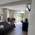 Résidence Les Cigales in Porto-Vecchio: hotel room with king bed, desk, chairs, and balcony doors