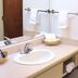 Avalon Inn in Sandusky bathroom with sink, mirror, towels, and shower-tub combo