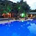 The Sarigerme Inn in Sarigerme, lit outdoor pool beside trees and guest rooms at dusk