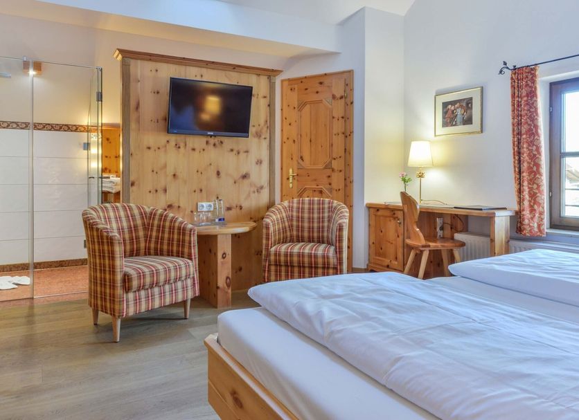 Landgasthof zum Erdinger Weißbräu guest room in Rosenheim with twin beds, seating area, desk and TV
