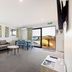Kaikoura TOP 10 Holiday Park lounge with sofa, dining table and deck view in Kaikoura