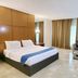 Hotel Apita Cirebon in Cirebon guest room with bed, sofa, and floor-to-ceiling curtains