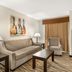 Best Western Plus Valdosta Hotel & Suites guest room with sofa, armchair, coffee table and wall art