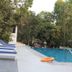 Le Pearl Goa Resort & Spa in Vagator: outdoor pool with blue loungers and trees