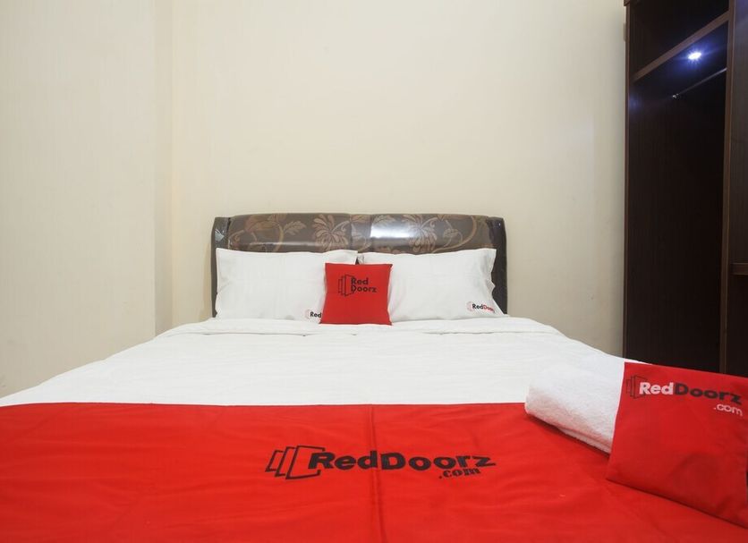 RedDoorz near Terminal Bungur Asih, Surabaya room with white bed and red bedding