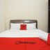 RedDoorz near Terminal Bungur Asih, Surabaya room with white bed and red bedding