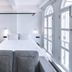 Hotel Mono Singapore guest room with king bed, gray sofa, and tall arched windows
