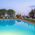 Villa Borgo San Pietro in Cortona outdoor pool with loungers and garden views at dusk