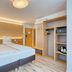 Hotel Leipziger Hof Innsbruck twin bed room with wood-paneled wall and open wardrobe