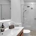 Tasman Holiday Parks - Papamoa Beach bathroom with glass shower, vanity, toilet and towel rails in Papamoa