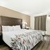 Red Roof Inn & Suites Duncan guest room with king bed, bedside lamps, and window curtain