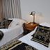 Rio Arriba Suites Apartments y Resto in Bella Vista, twin beds with black-and-gold patterned bedding and bedside lamp