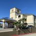 Galveston Beach Hotel in Galveston with a covered entrance, palm trees, and blue sky