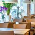 Auto-Parkhotel Hamburg St Pauli dining room with tables, tan chairs, pendant lights and potted plants