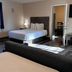Coastal Inn and Suites in Long Beach room with bed, TV, window, and sitting area