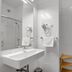 7Days B&B in Bratislava bathroom with wall-mounted sink, glass shower, and towel rack