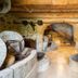 Tenuta Ciminata Greco in Rossano, rustic stone cellar lounge with arches, stairs, and wine barrels