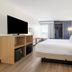 Spark by Hilton Harrisonburg University Area guest room with king bed, TV, desk, and open closet in Harrisonburg
