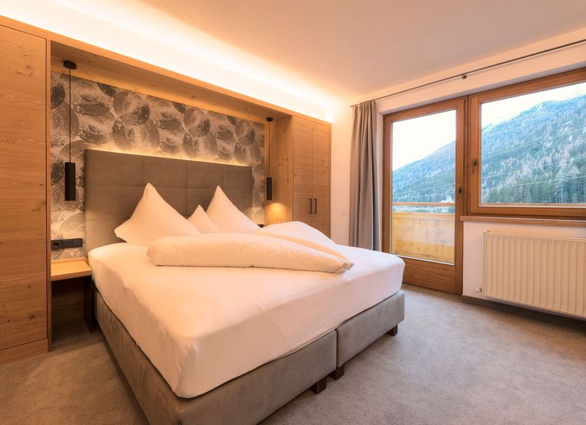 Hotel Garni Feuerstein bedroom in Sankt Anton am Arlberg with mountain view balcony