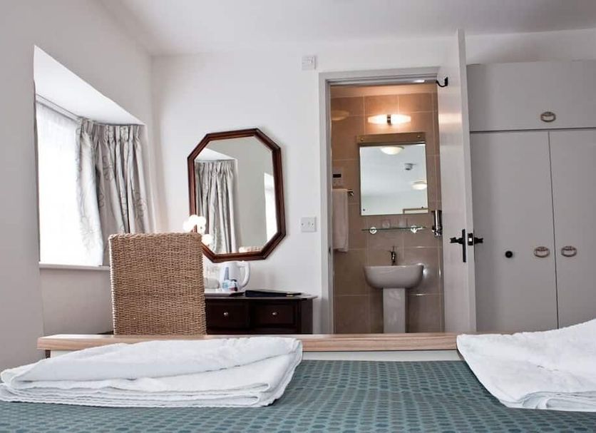 The Blenheim Buttery in Woodstock guest room with twin beds, vanity mirror, and ensuite bathroom