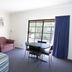 Tocumwal Golf Resort in Tocumwal guest room with bed, sofa, table and chairs, and window view