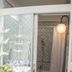 Residence Palazzo Baldi in Galatina: bathroom with walk-in shower, vanity sink, and round wall light