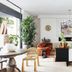 Basq House Byron Bay lounge with sofa, rattan chair, sideboard and large windows